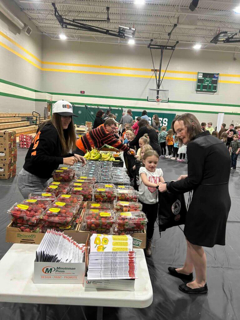eastern_local_elementary_HBHM_produce A girl with her mom putting strawberries in her bag at The Joe Burrow Foundation's Healthy Body, Healthy Minds event at Eastern Local Elementary School.